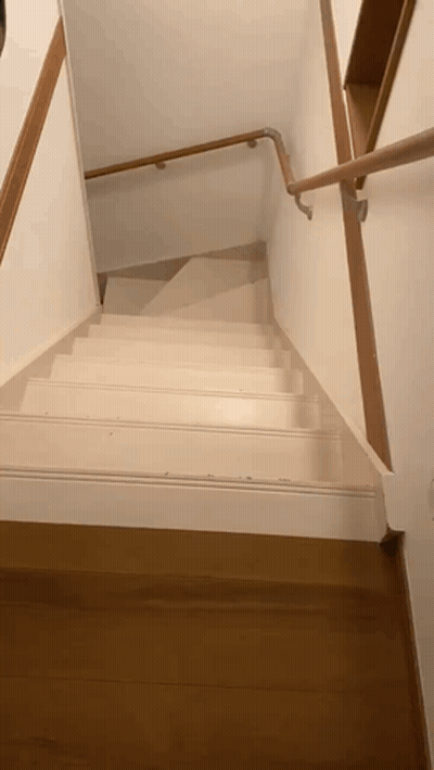 a white staircase with a wooden railing and a wooden floor
