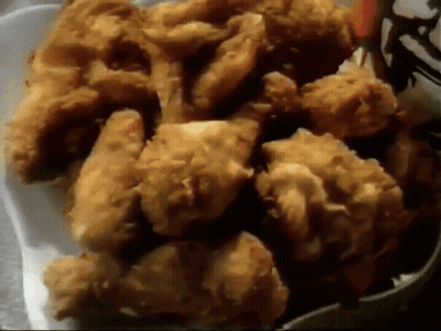 a white styrofoam container filled with fried chicken