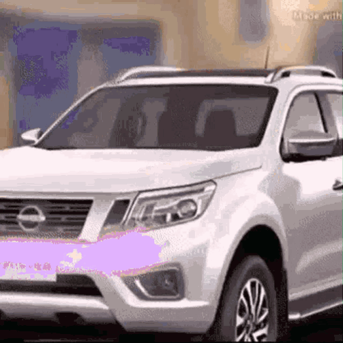 A White Suv Is Parked In Front Of A Building . GIF