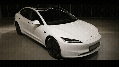 A White Tesla Is Parked In A Dark Room GIF