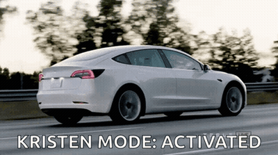 A White Tesla Model 3 Is Driving Down A Highway With Kristen Mode Activated GIF