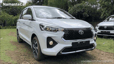 A White Toyota Car Is Parked In A Grassy Field With Namastecar Written On The Bottom GIF