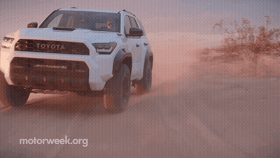 A White Toyota Is Driving On A Dirt Road In The Desert GIF