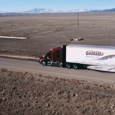 A White Truck Is Driving Down A Desert Road GIF