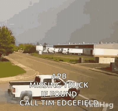 A White Truck Is Driving Down A Street With The Words " Apb Missing Truck If Found Call Tim Edgefield " GIF