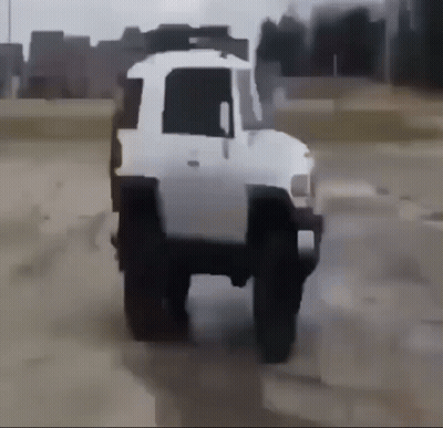 A White Truck Is Driving Through A Dirt Field GIF