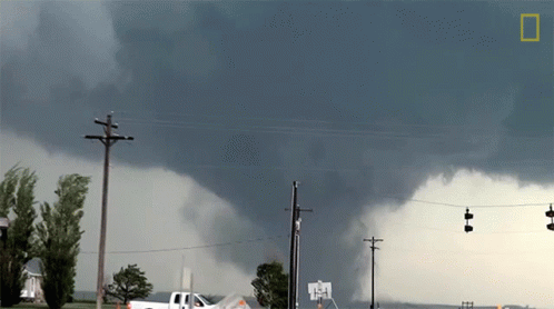 A White Truck Is Parked In Front Of A Large Storm GIF