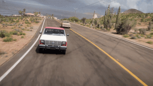 A White Truck With A Red Top Is Driving Down The Road GIF