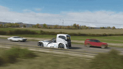 A White Truck With The Word Volvo On The Side Is Driving Down The Road GIF