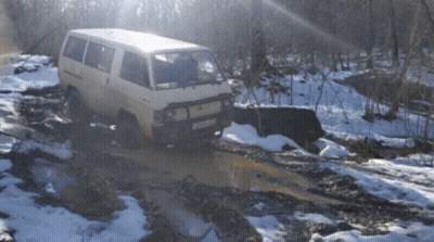 A White Van Is Driving Through A Muddy Puddle With A License Plate That Says Rc - 029 GIF