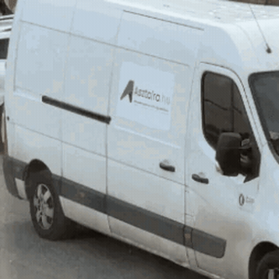 A White Van Is Parked On The Side Of The Road And Has A Sticker On The Side That Says A. GIF