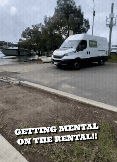 A White Van Is Parked On The Side Of The Road With The Words " Getting Mental On The Rental " Below It GIF