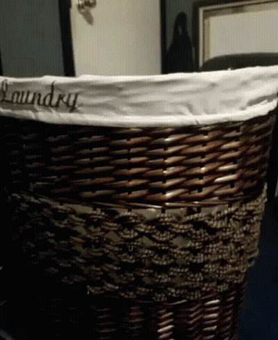 A Wicker Laundry Basket With The Word Laundry Embroidered On It GIF