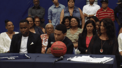 A Wilson Basketball Sits On A Table In Front Of A Crowd GIF
