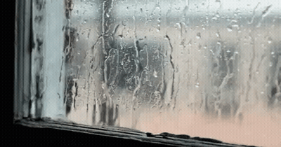 A Window With Rain Drops On It And A Person Looking Out . GIF