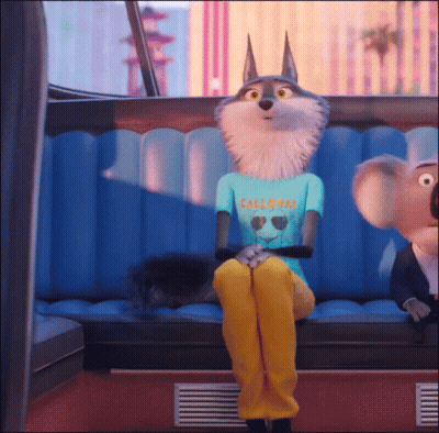 A Wolf Wearing A California Shirt Sits On A Blue Couch GIF