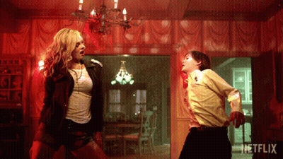 A Woman And A Boy Are Dancing In A Room With A Netflix Logo GIF