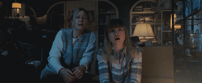 A Woman And A Girl Are Sitting In A Dark Room Looking At Something GIF