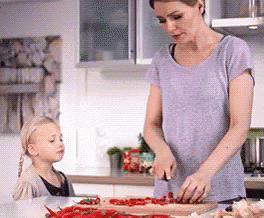 A Woman And A Little Girl Are Preparing Food In The Kitchen GIF