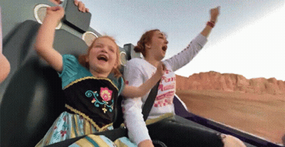 A Woman And A Little Girl Are Riding A Roller Coaster And The Little Girl Is Wearing A Frozen Dress GIF