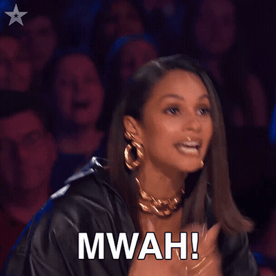 A Woman Applauds In Front Of A Crowd With The Words Mwah Written On Her Face GIF