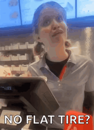 A Woman Behind A Counter With The Words No Flat Tire Below Her GIF