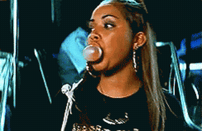 A Woman Blowing A Bubble With A Black Shirt On GIF