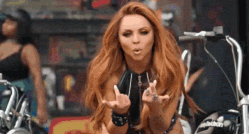 A Woman Blowing A Kiss While Riding A Motorcycle GIF