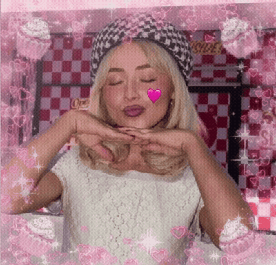 A Woman Blowing A Kiss With Cupcakes In The Background And A Sign That Says Outside GIF