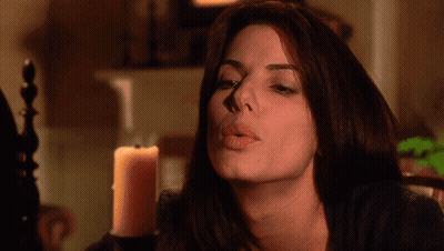 A Woman Blows A Kiss In Front Of A Lit Candle GIF