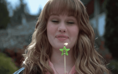 A Woman Blows Out A Green Star Candle GIF