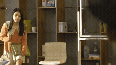 A Woman Carrying A Book That Says ' French ' On It GIF