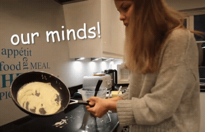 A Woman Cooking In Front Of A Wall That Says Our Minds On It GIF