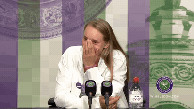 A Woman Covering Her Face While Sitting In Front Of A Bottle Of Evian Water GIF
