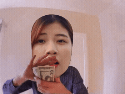 A Woman Covering Her Face With A Stack Of Money GIF