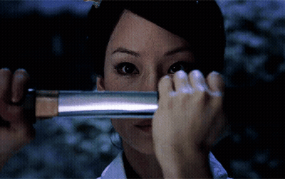 A Woman Covering Her Face With A Sword GIF