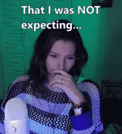 A Woman Covering Her Mouth With Her Hand While Sitting In Front Of A Microphone . GIF
