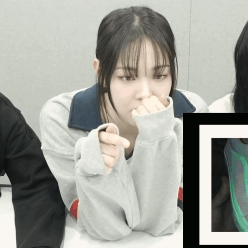 A Woman Covering Her Mouth With Her Hands While Sitting At A Table With Another Woman GIF