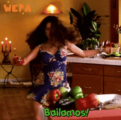 A Woman Dancing In A Kitchen With The Words Bailamos GIF
