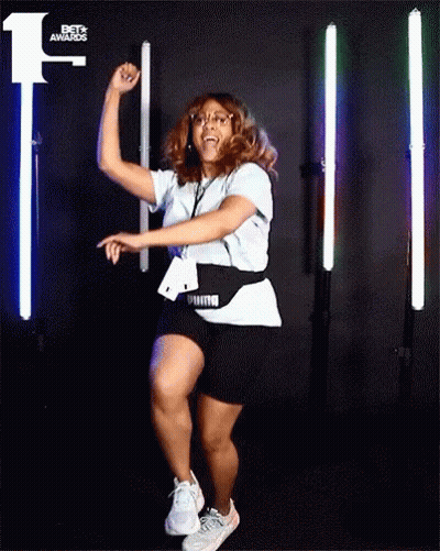 A Woman Dancing In Front Of A Bet Awards Sign GIF
