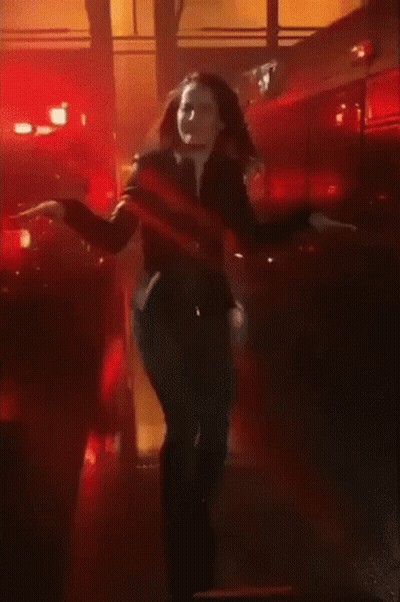 A Woman Dancing In Front Of A Fire Truck GIF