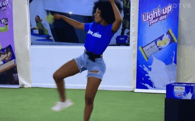 A Woman Dancing In Front Of A Light Up Your Day Advertisement GIF