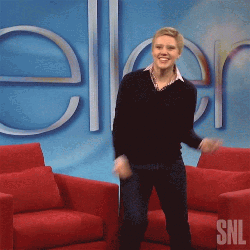 A Woman Dancing In Front Of A Sign That Says Snl GIF
