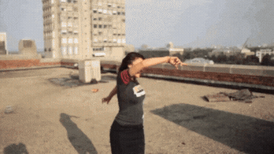 A Woman Dancing On A Rooftop Wearing A Shirt That Says ' Chicago ' On It GIF
