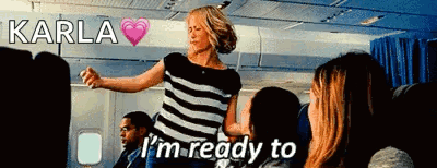 A Woman Dancing On An Airplane With The Words I 'M Ready To Below Her GIF