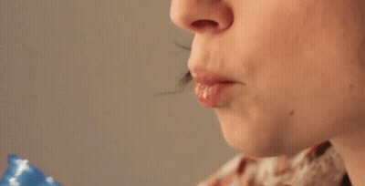 A Woman Drinking From A Blue Cup With Her Mouth Open GIF