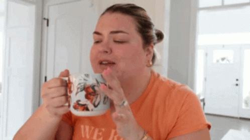 A Woman Drinking From A Mug That Says We GIF