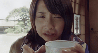 A Woman Drinking From A Small White Cup GIF