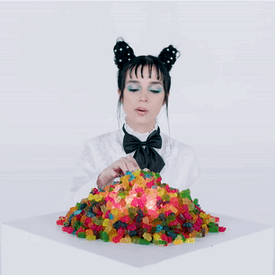 A Woman Eating A Pile Of Gummy Bears GIF