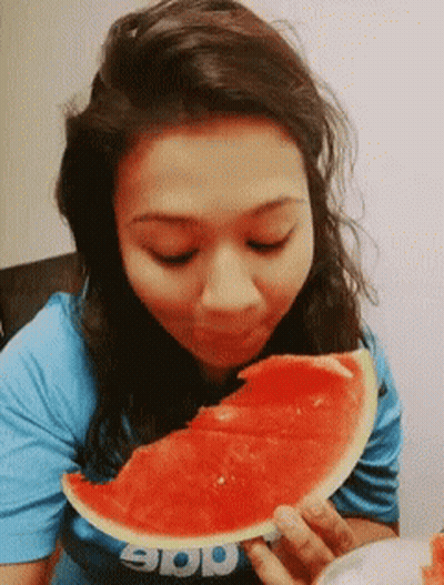 A Woman Eating A Slice Of Watermelon Wearing A Shirt That Says App GIF